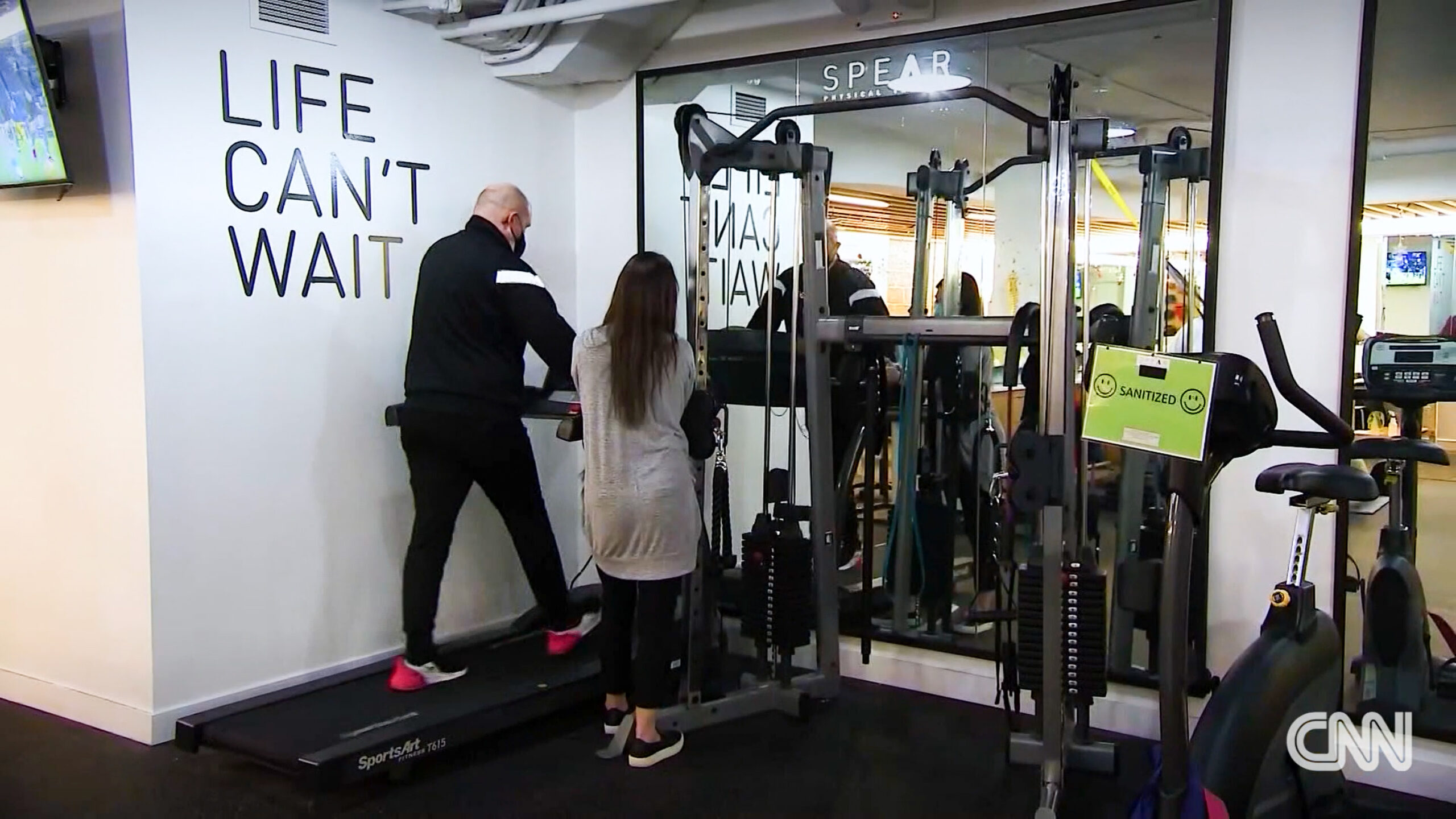 spear physical therapist with a patient walking on a treadmill